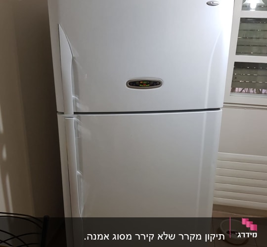 מקרר לבן עם ידיות ומדבקות על הדלת